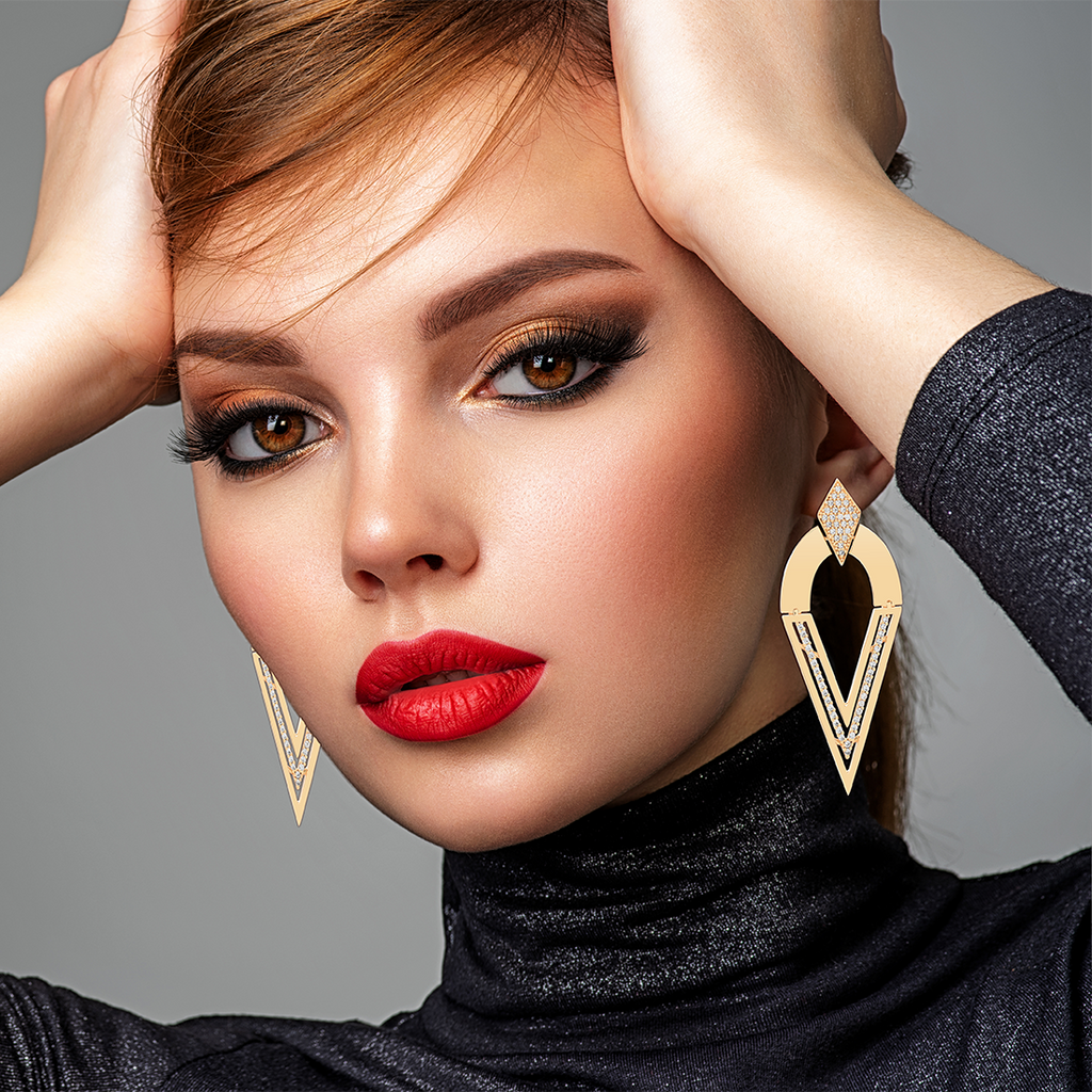 Model wearing diamond shaped gold statement earrings by Mcristals