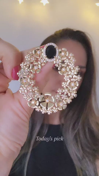 Closeup video showing golden statmente earrings on the ear.